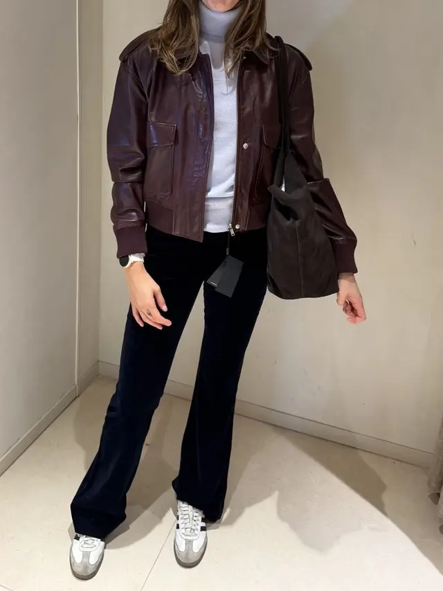 Burgundy leather jacket, white turtleneck and black trousers