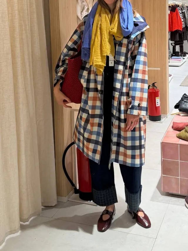 Checked coat with blue and yellow scarves, dark cuffed jeans and burgundy shoes